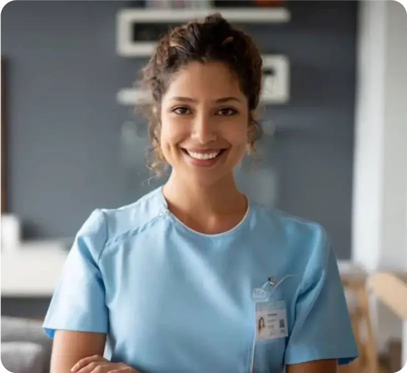nurse wearing scrubs with crossed arms smiling at camera